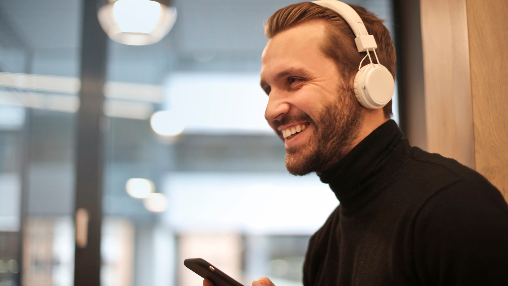Man practicing shadowing technique with headphones while looking at phone