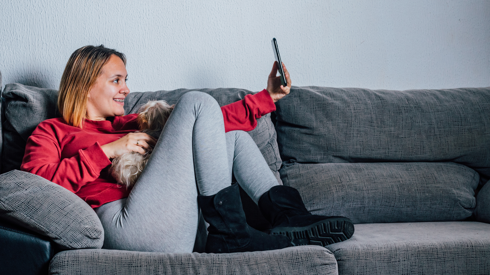 Woman relaxing on couch using smartphone to connect with language partners